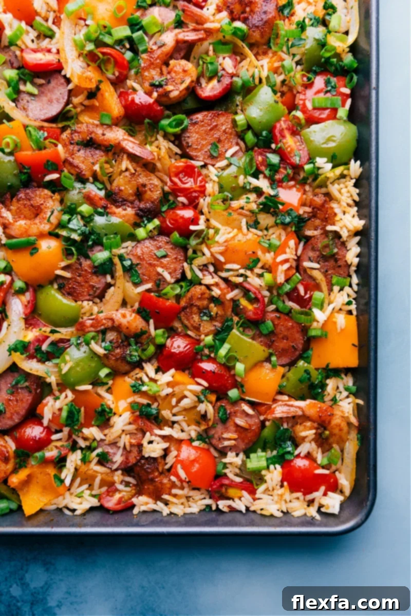 A sheet pan brimming with One Pan Jambalaya, featuring seasoned sausage, succulent shrimp, vibrant veggies, and flavorful rice.