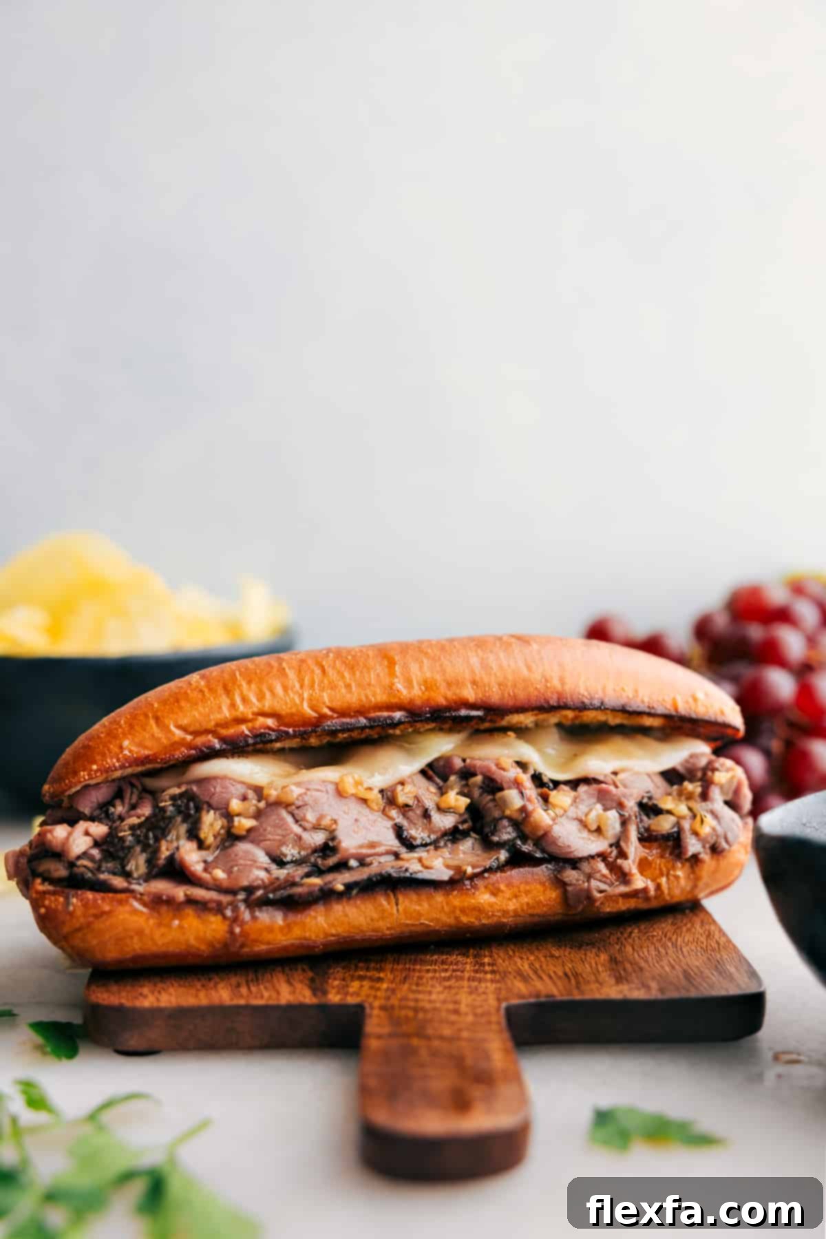 Mouthwatering melty French Dip Sandwiches with a side of au jus, ready for dipping and enjoying.