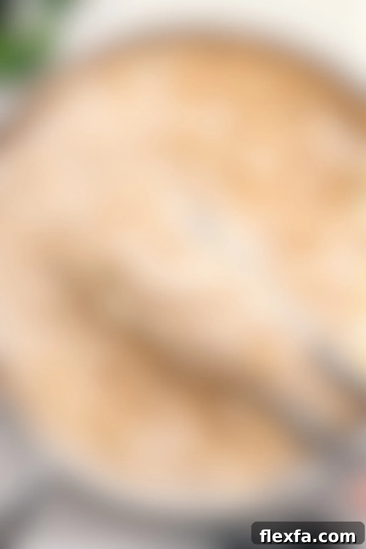 A large scoop of creamy and delicious Olive Garden Fettuccine Alfredo being lifted from a pot, showcasing its rich texture.