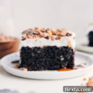 Finished Chocolate Poke Cake with a slice removed, displaying the moist interior and caramel soak.