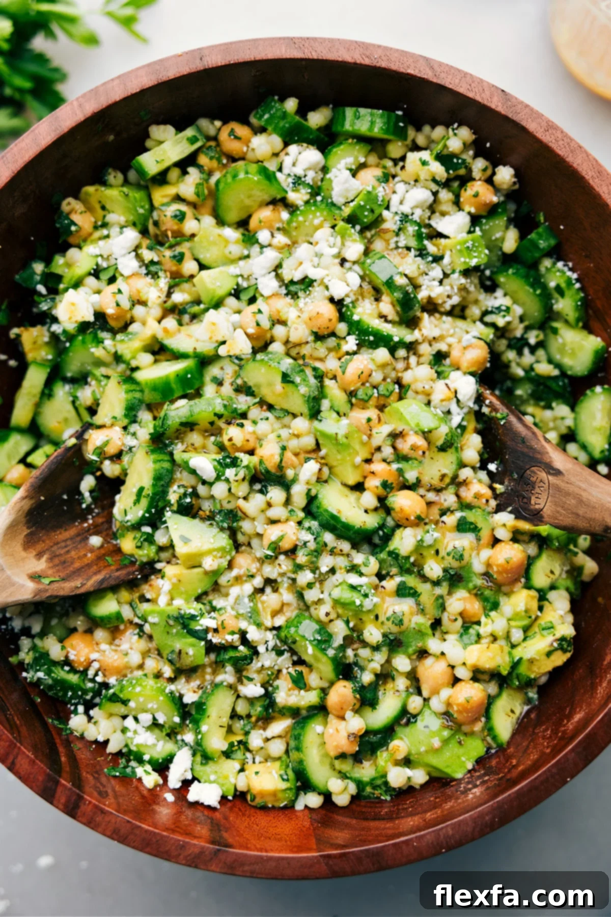 A fresh and vibrant cucumber feta salad, tossed with dressing, ready to be enjoyed as a refreshing side or light meal.