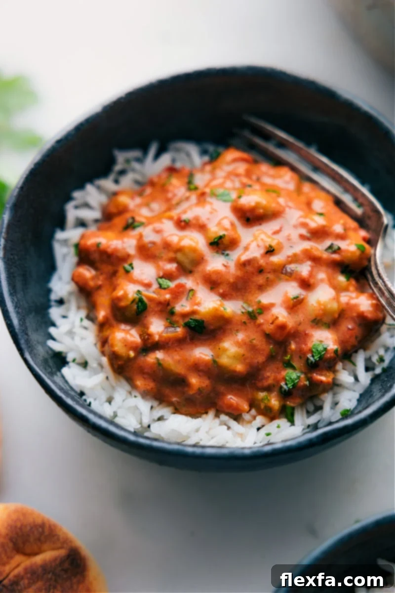 A delicious bowl of Butter Chickpeas, a plant-based version of butter chicken, served over rice with a creamy tomato sauce.