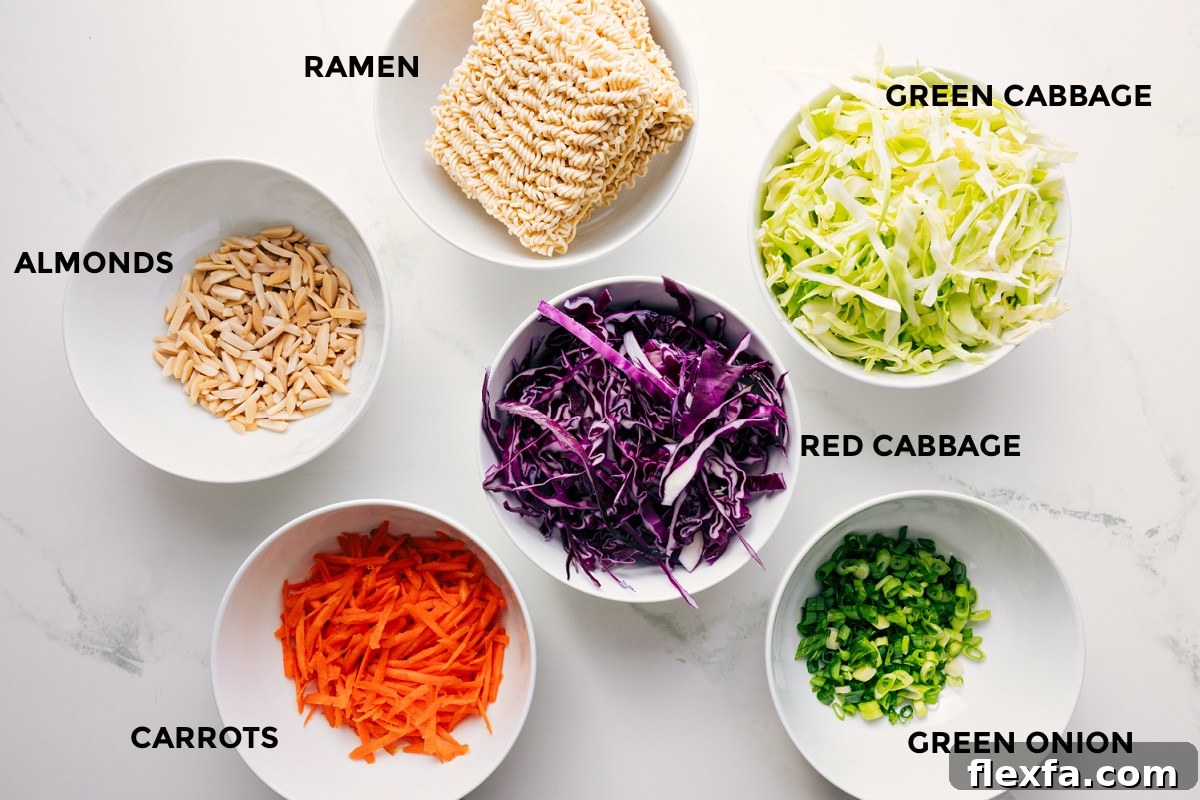 All the ingredients in this recipe prepped out for easy assembly including the almonds, carrots, cabbage, green onions, and ramen.