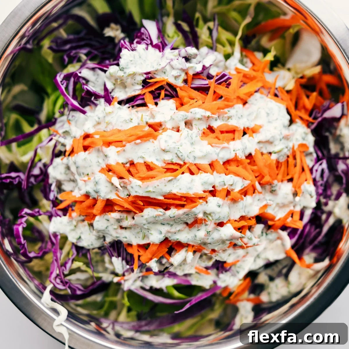 All the ingredients added to a large bowl with the dressing drizzled on top.