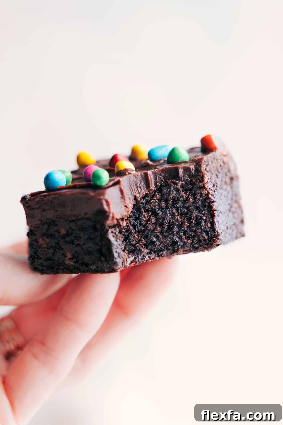 Cosmic Brownies Recipe held up with a large bite taken out of one brownie.