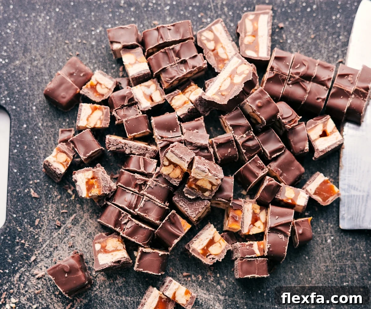 The Snickers for this Snickers salad recipe chopped up on the cutting board.