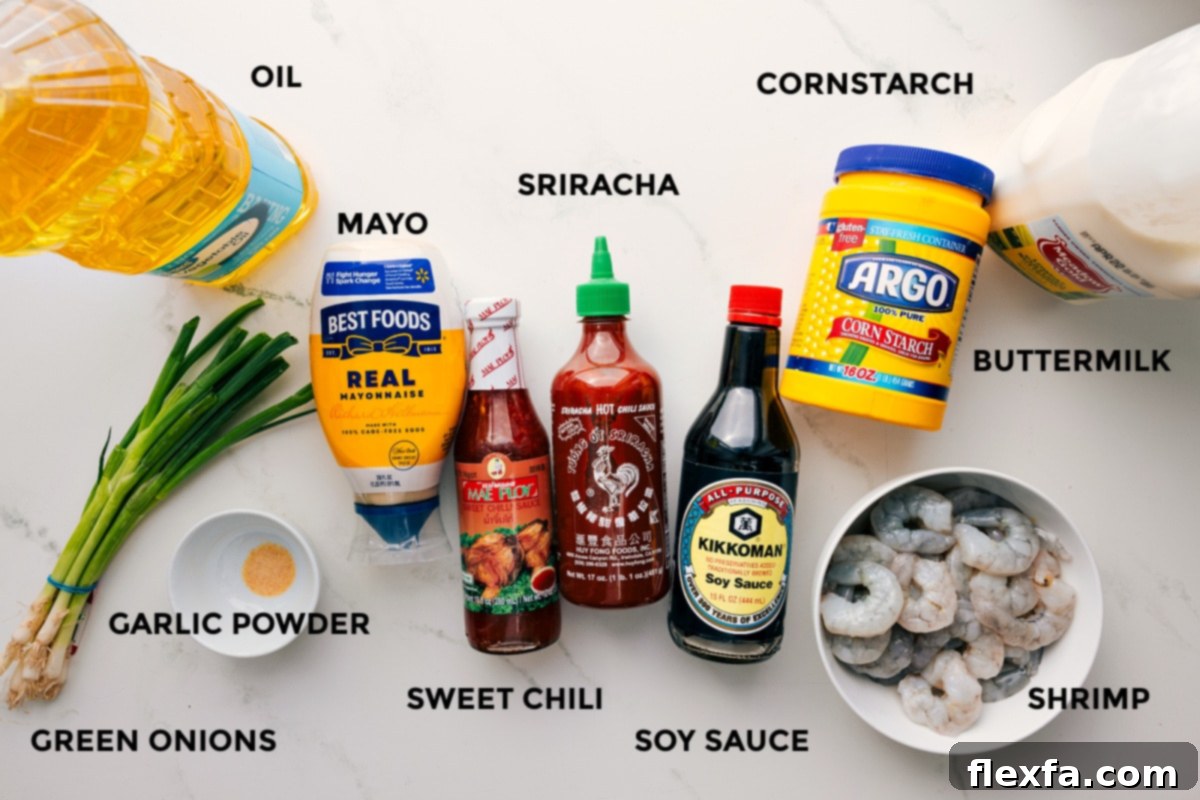 An overhead shot of all the ingredients for Bang Bang Shrimp laid out on a countertop, including shrimp, buttermilk, cornstarch, mayonnaise, sweet chili sauce, sriracha, soy sauce, and green onions.