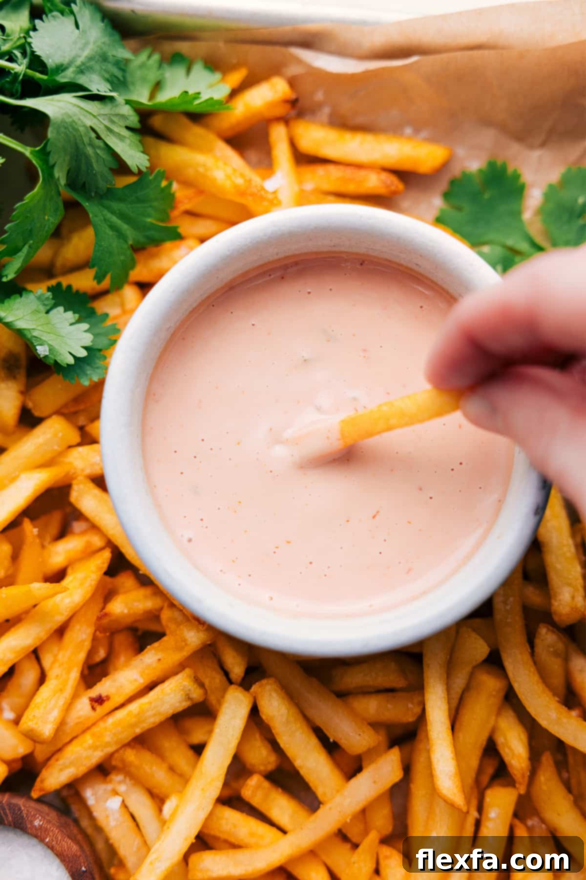 A french fry dipping into a small bowl of homemade In-N-Out Sauce.