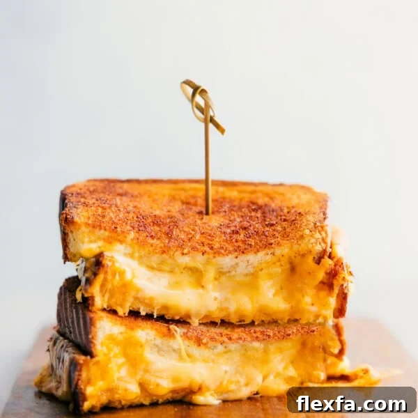 Grilled Cheese stacked on top of each other showing the cheesy center.