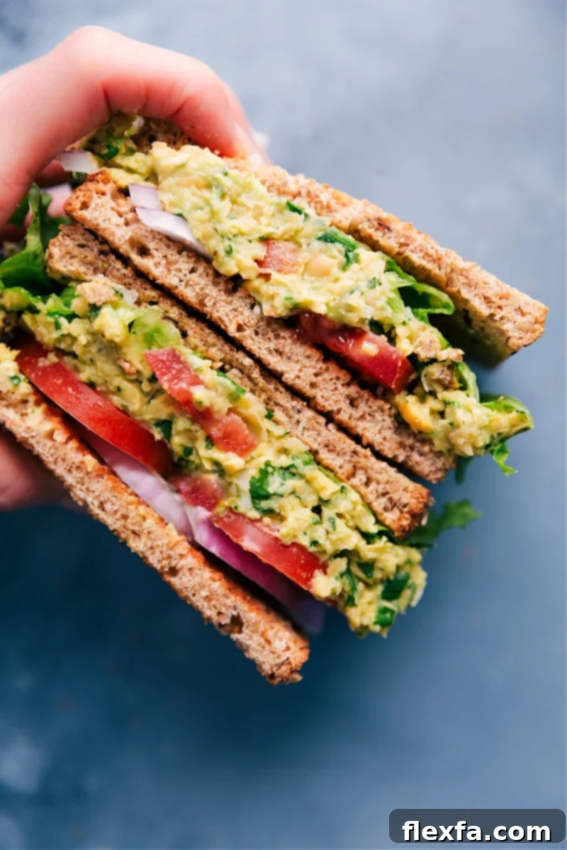A creamy chickpea salad sandwich cut in half on toasted bread.