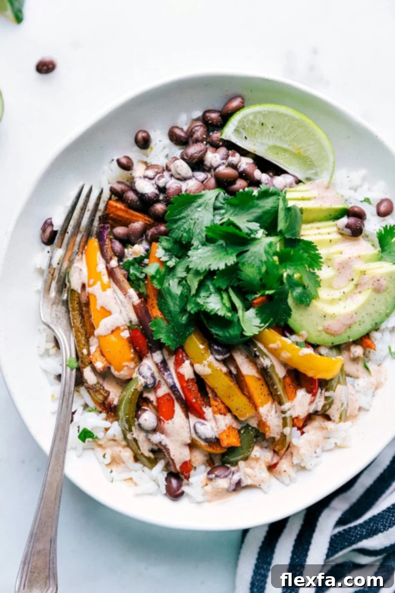 A sheet pan with colorful vegetarian fajitas featuring sweet potatoes and bell peppers.