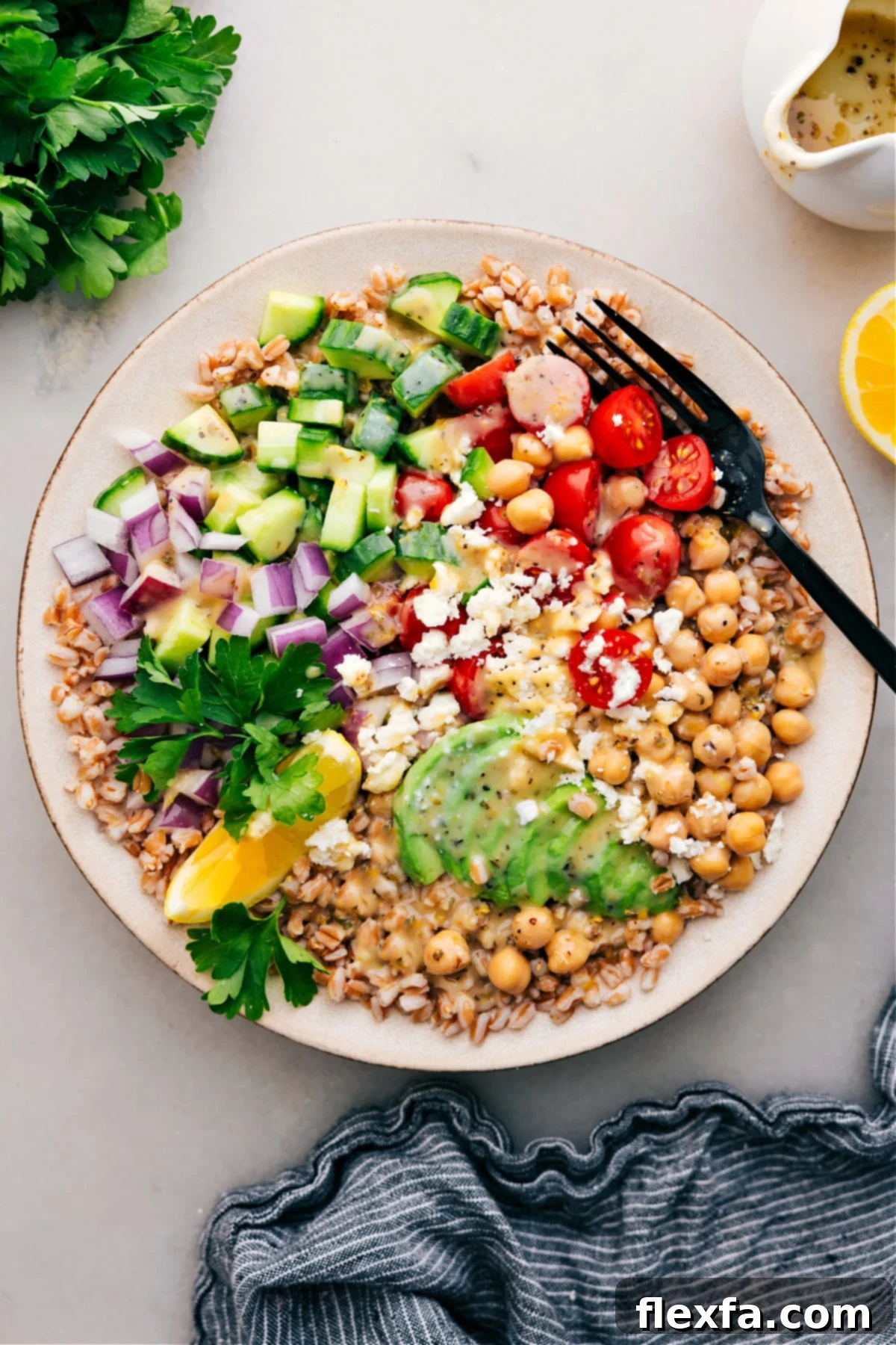 A healthy grain bowl with farro, fresh vegetables, chickpeas, and a light dressing.