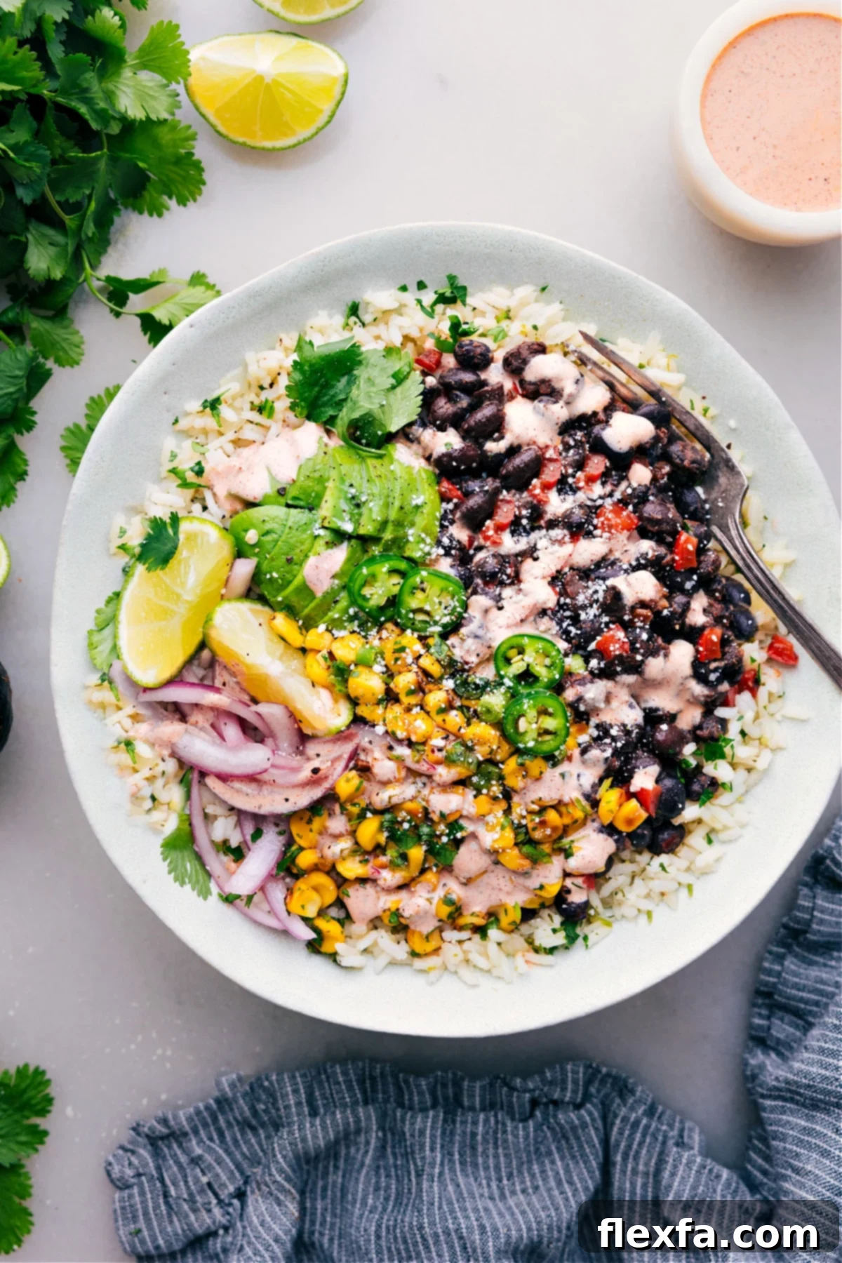 A black bean burrito bowl with cilantro-lime rice and a creamy chili-lime sauce.