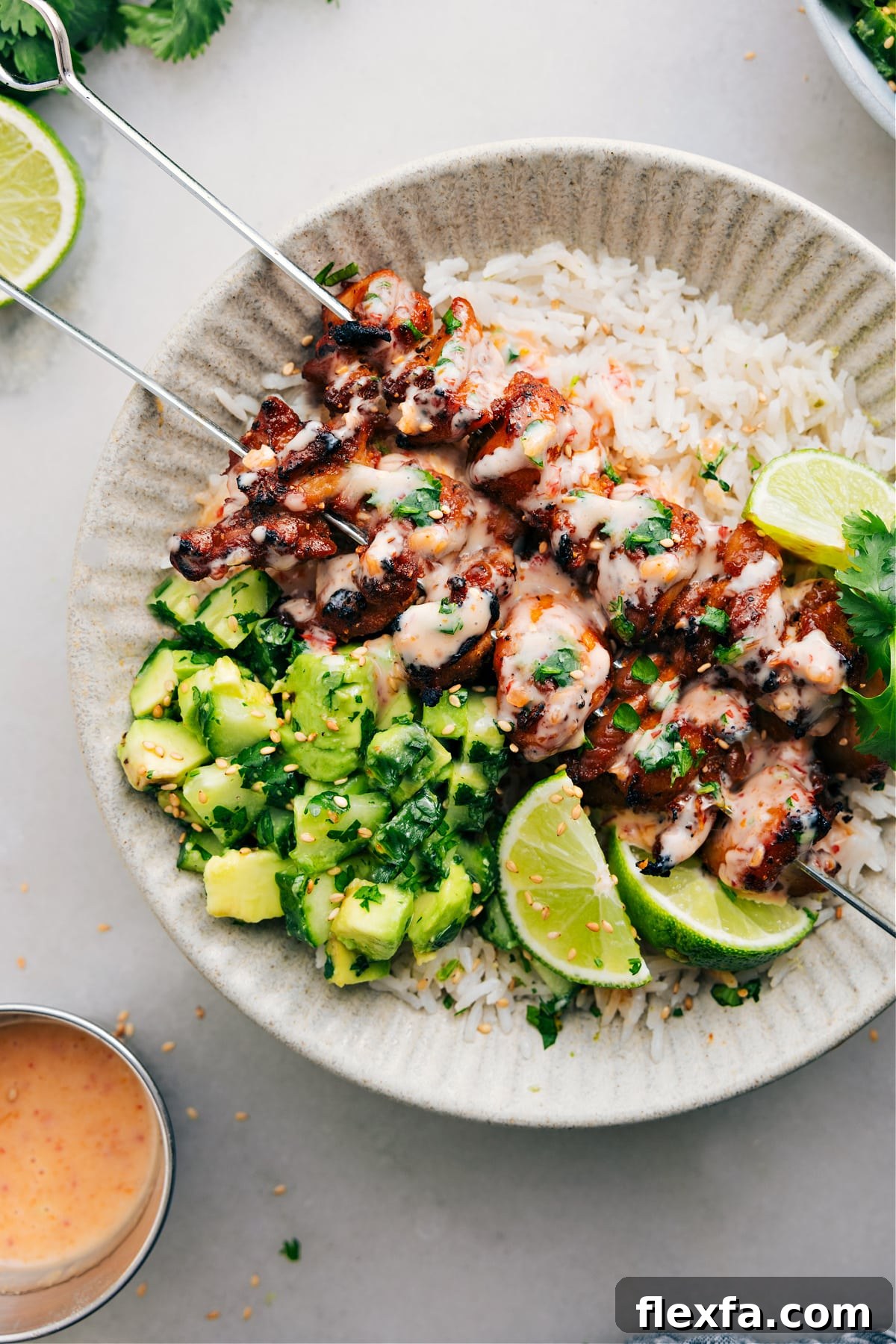 Bang bang chicken skewers with rice and a cucumber salad.