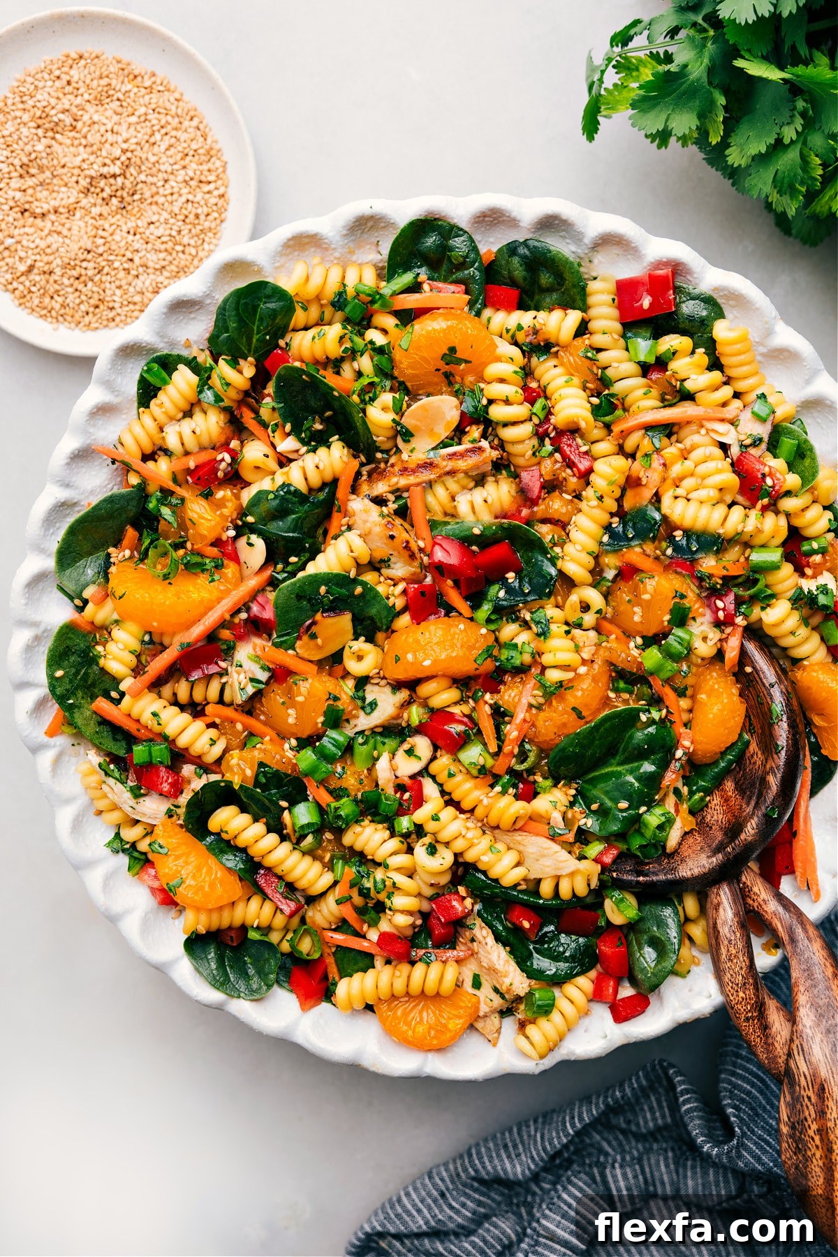 Asian pasta salad tossed with the dressing in a large bowl.