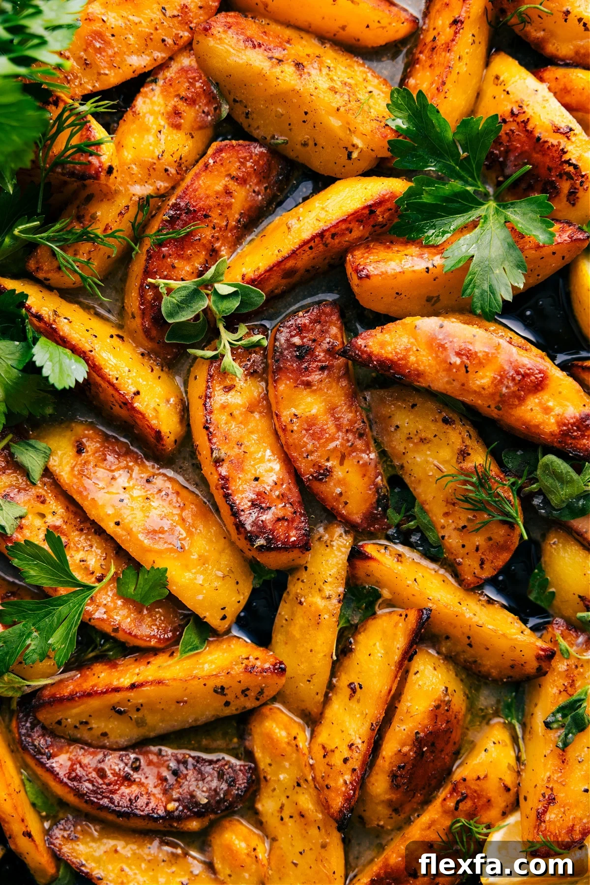 Greek potatoes recipe on a tray with fresh herbs.