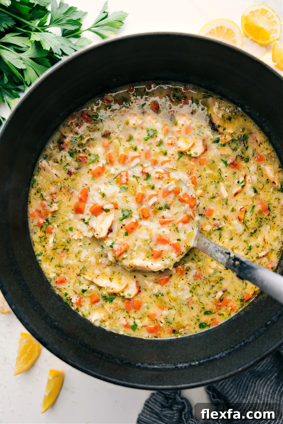 Lemon soup in the pot with a big ladle full coming out.