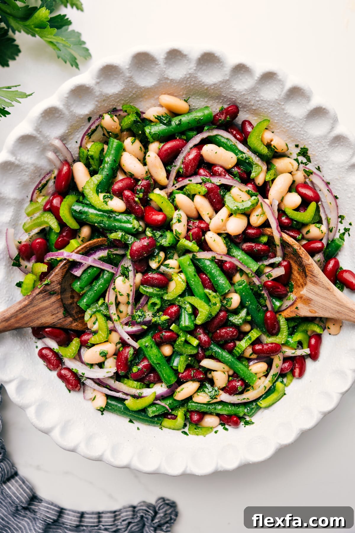 Three bean salad tossed with dressing in a bowl, ready to serve.