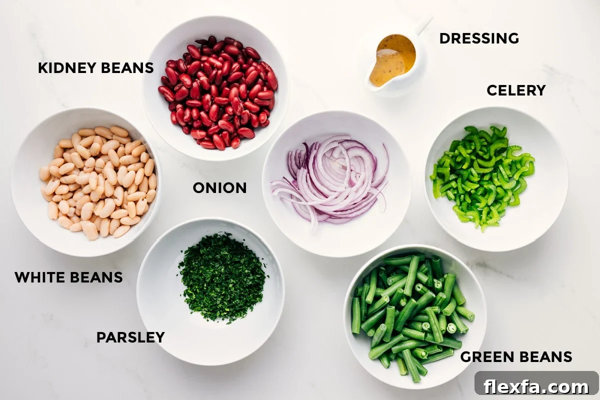 All the ingredients in this recipe prepped out for easy assembly including the beans, parsley, onion, green beans, celery, and dressing.