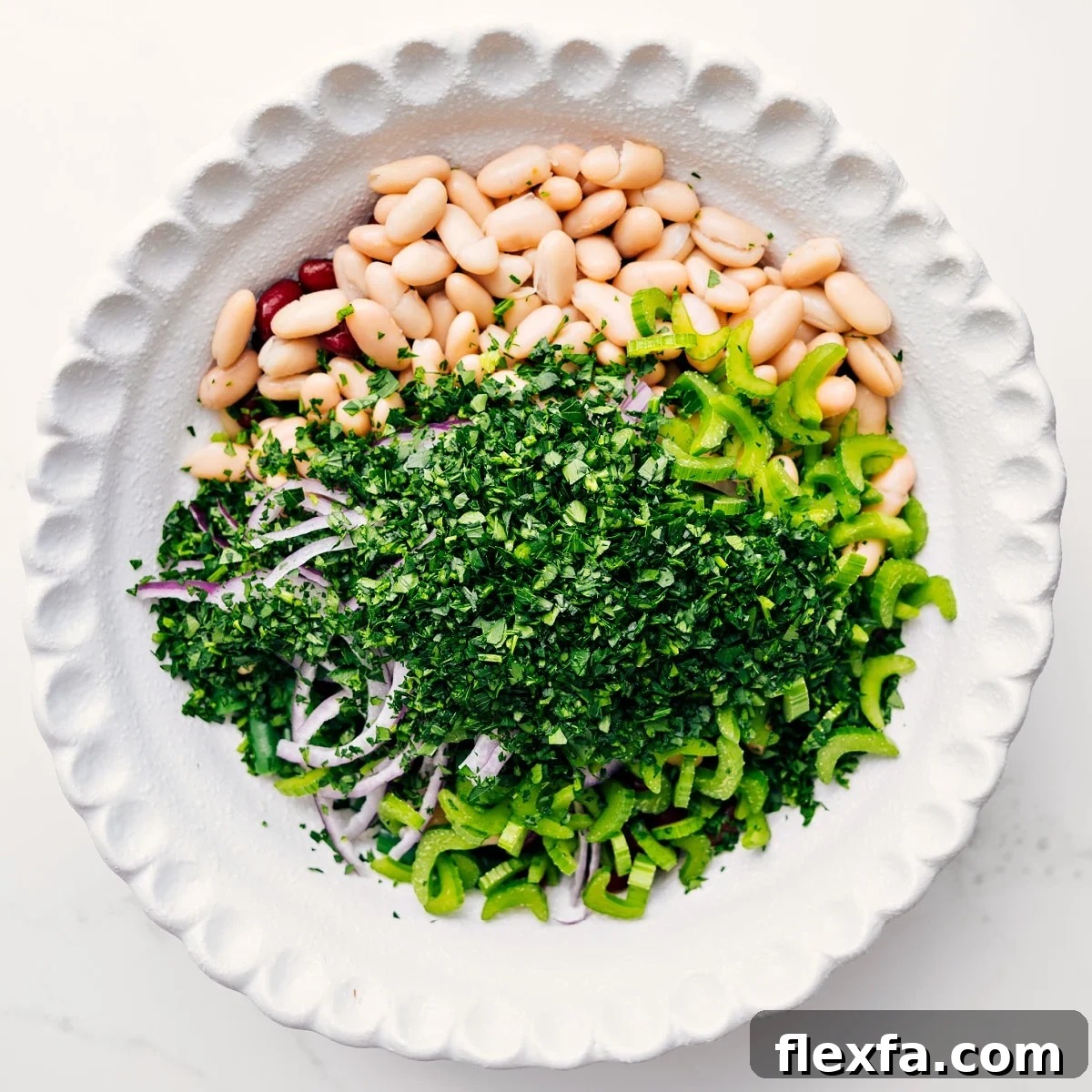 Three bean salad ingredients added to a bowl, ready to be tossed with dressing.