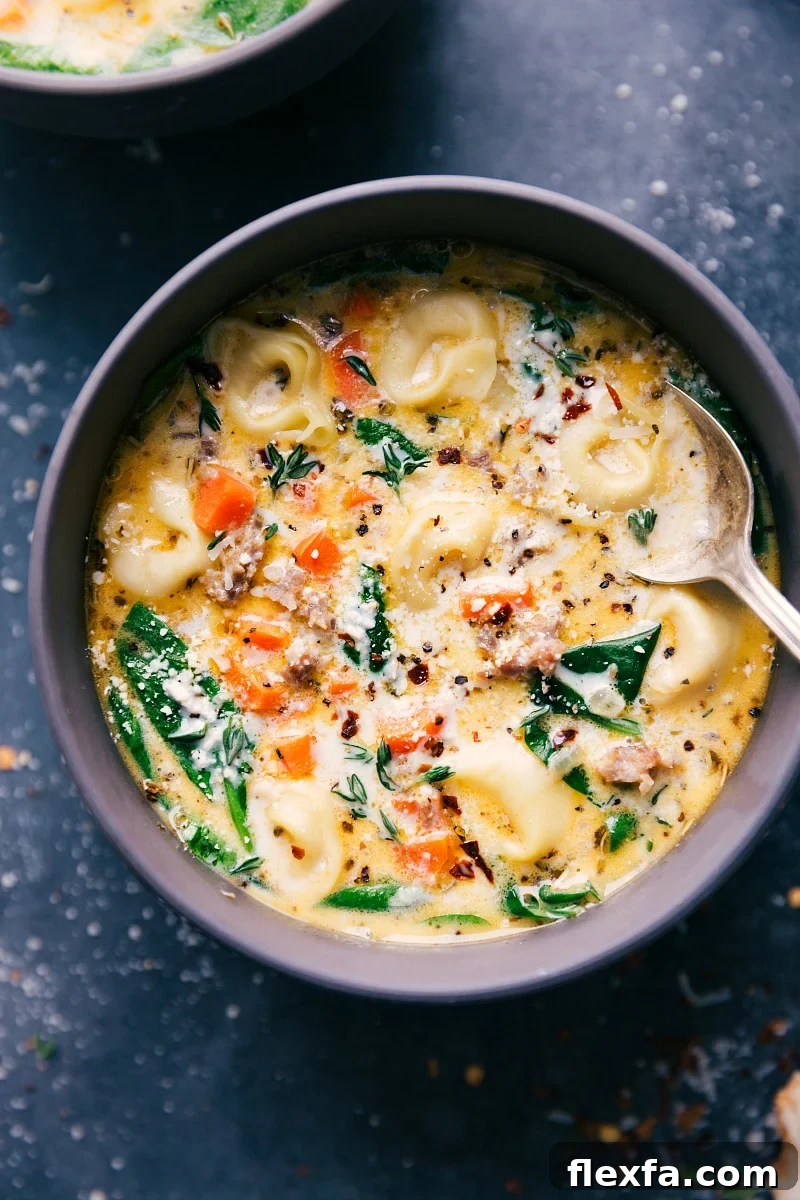 Sausage Tortellini Soup in a bowl with a spoon in it.
