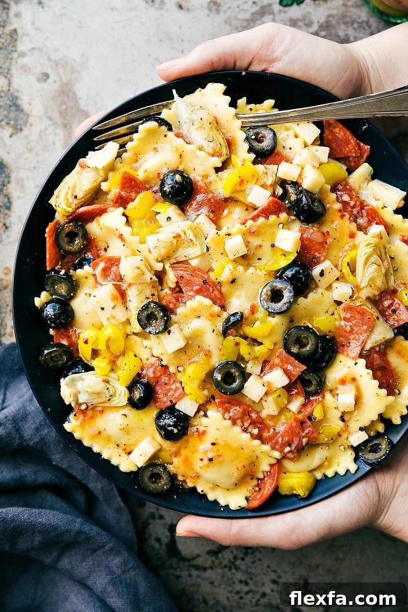 Italian recipes ravioli salad with cheese ravioli, pepperoni, provolone, artichokes, olives, and dressing.