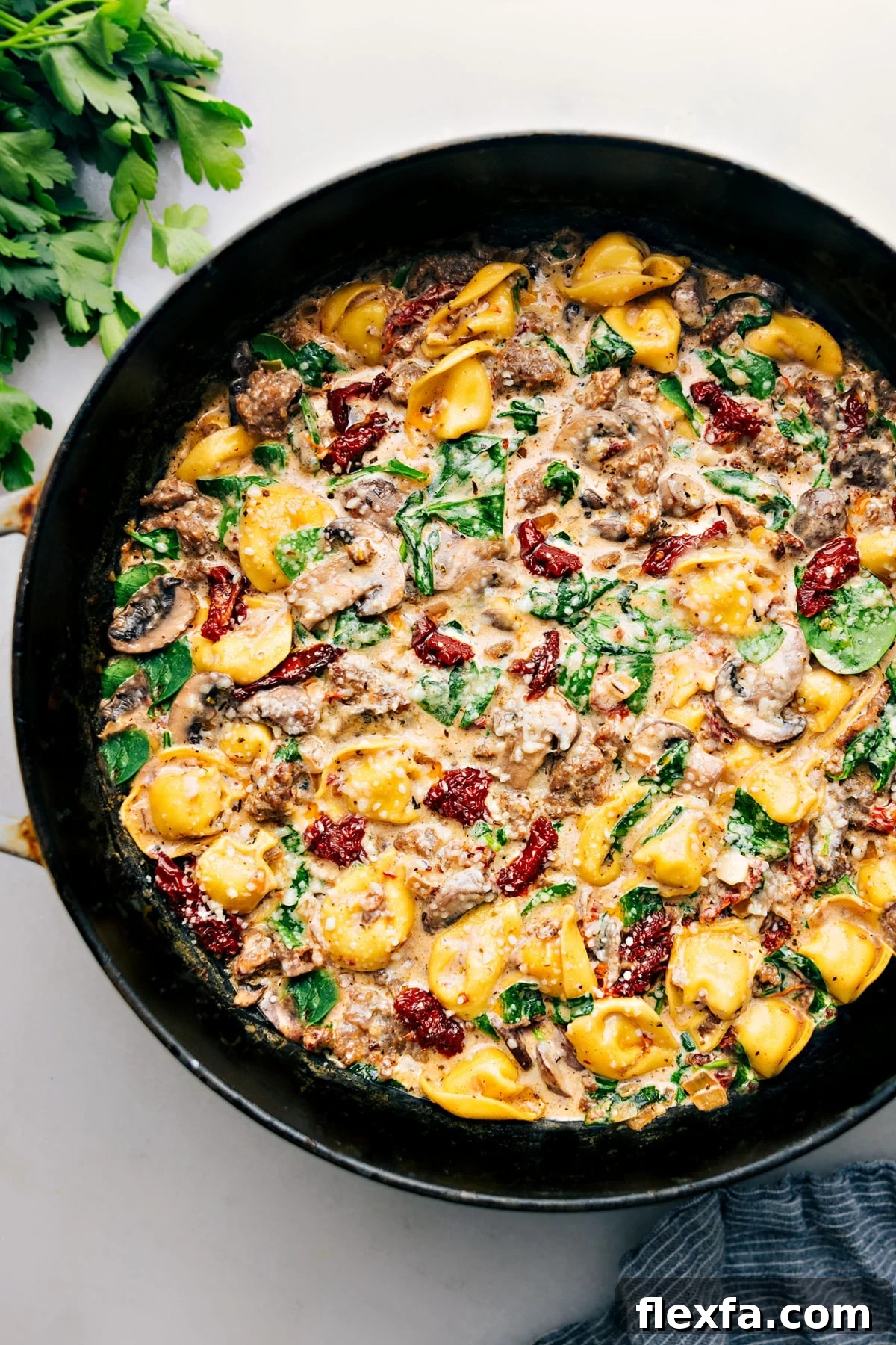 Tortellini bake with sausage, cheese tortellini, creamy sauce, and melted cheese.