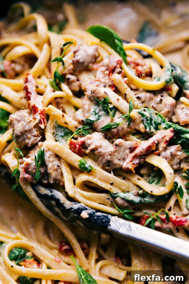 Creamy pasta with fettuccine, sausage, sun-dried tomatoes, spinach, and sauce.