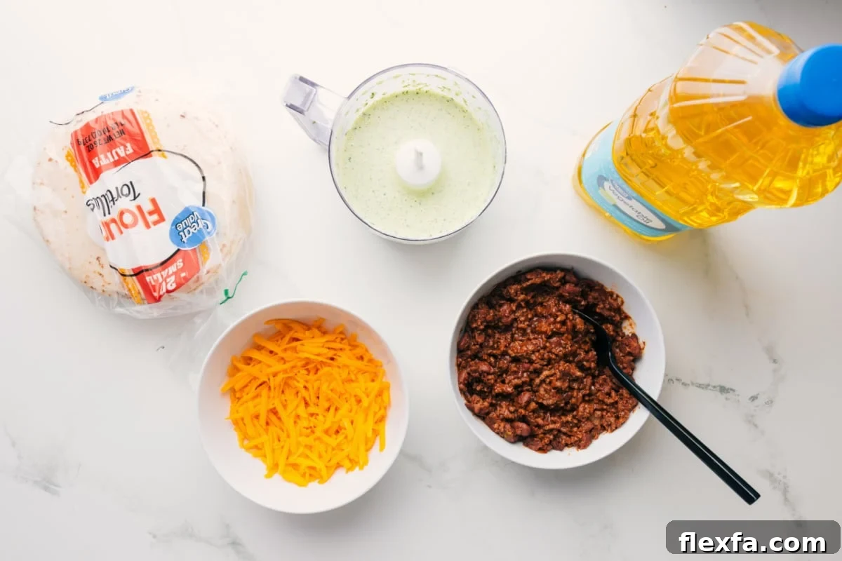 All the ingredients in this recipe prepped out for easy assembly including the tortillas, cheese, sauce, beef, and oil.