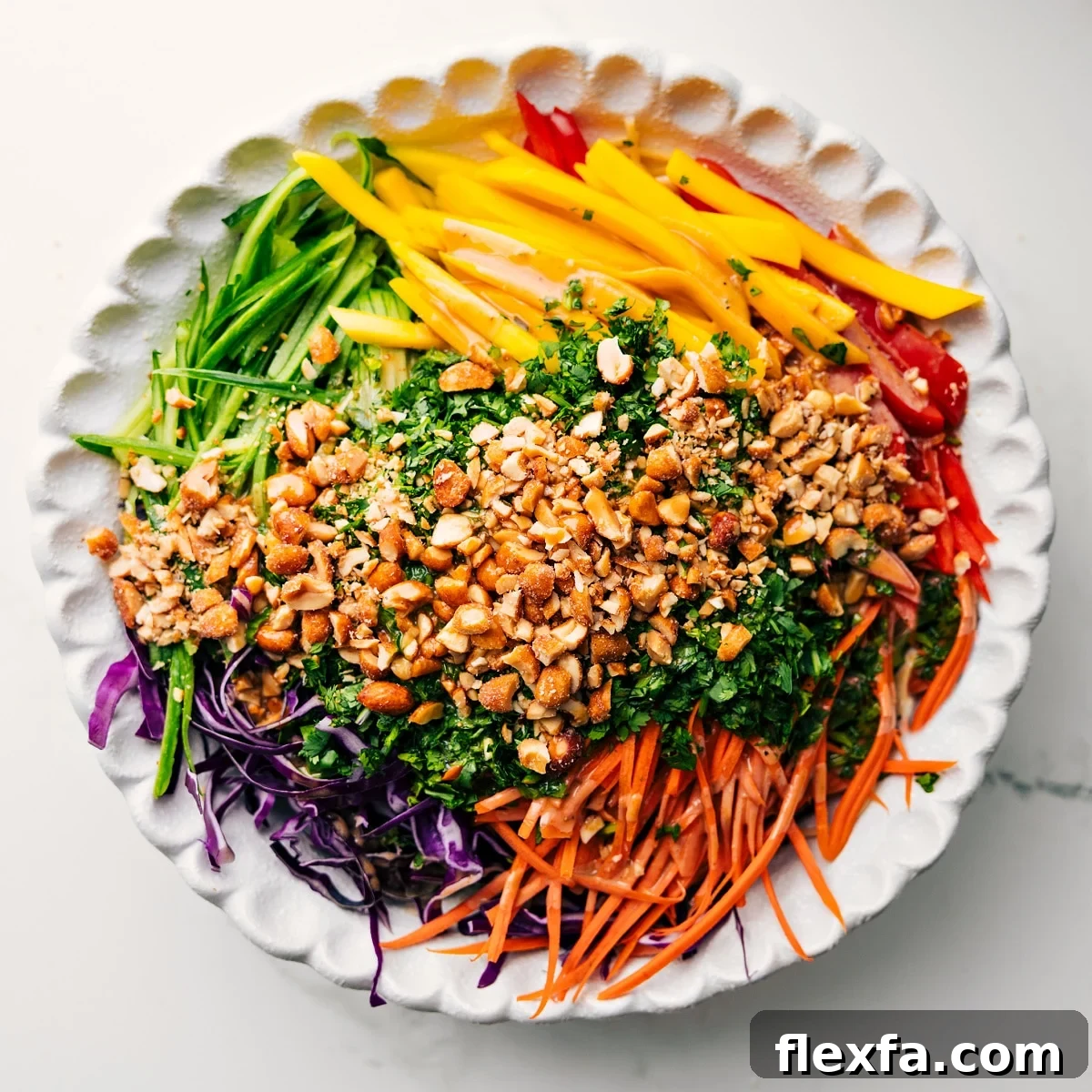 Adding all the ingredients for this spring roll salad into a large bowl to dress and toss together.