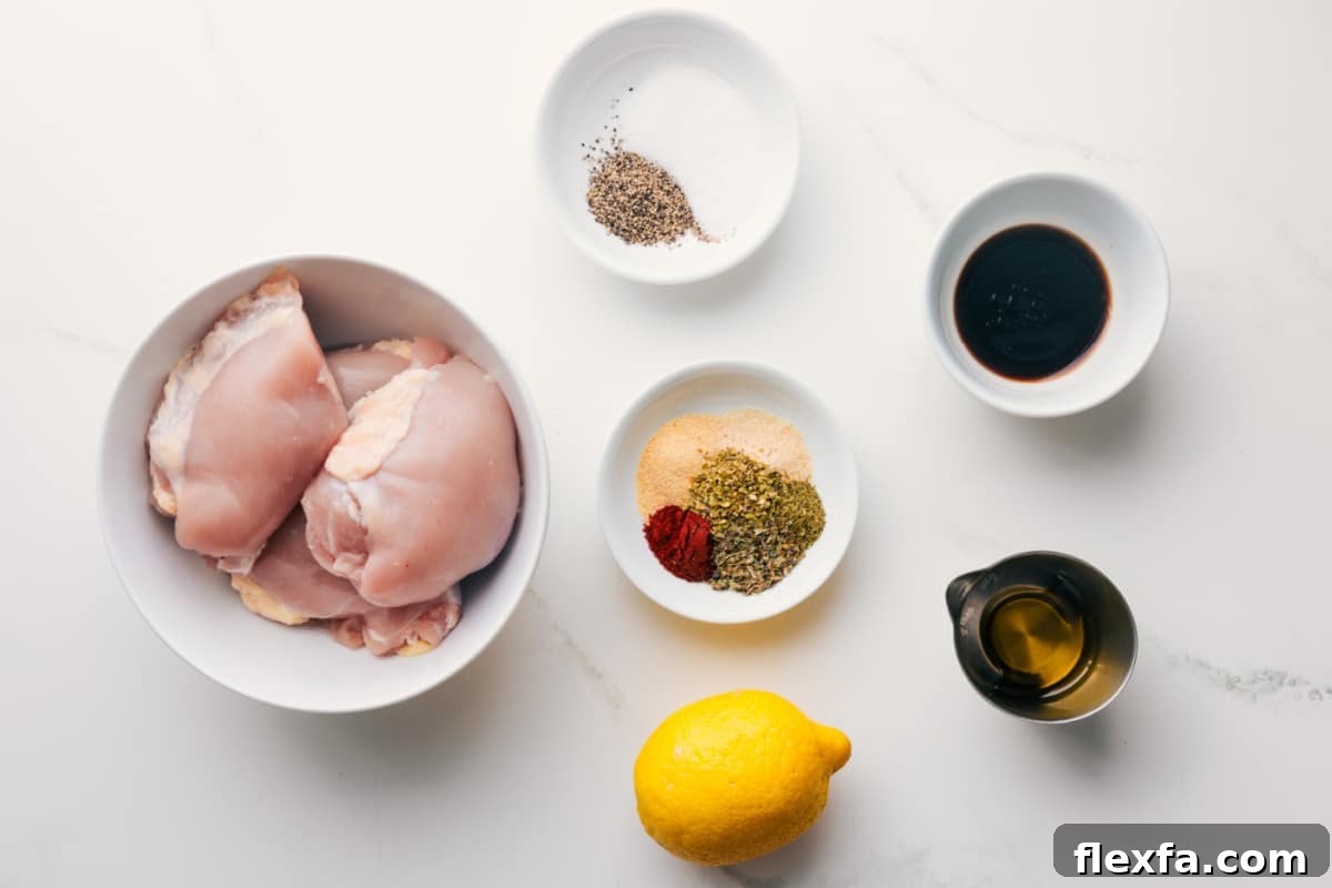 All the ingredients in this recipe prepped out for easy assembly including the chicken, seasonings, balsamic vinegar, lemon, and olive oil.