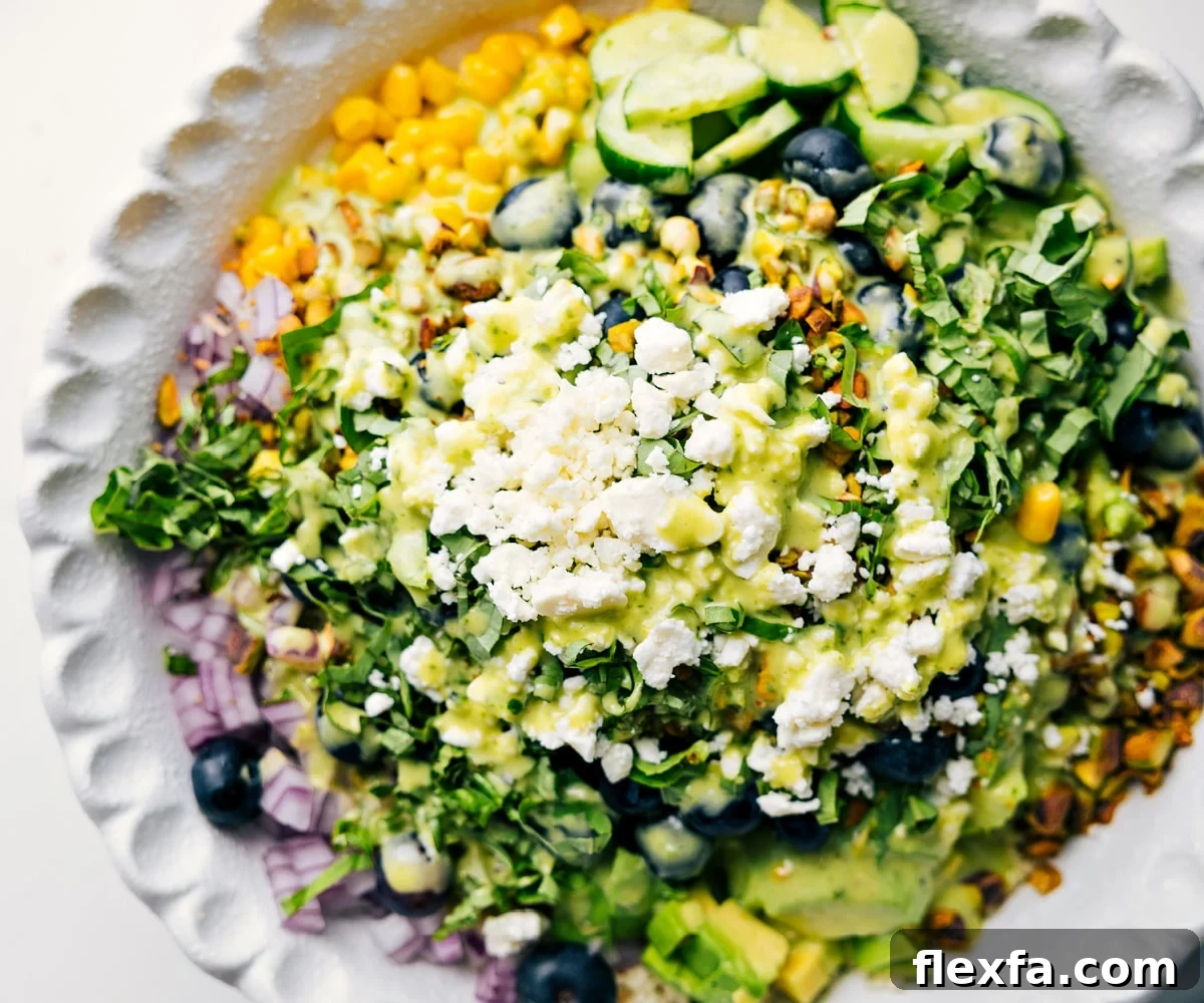 How To Make This Blueberry Salad Blueberry salad ingredients added to a bowl with dressing drizzled over the top.