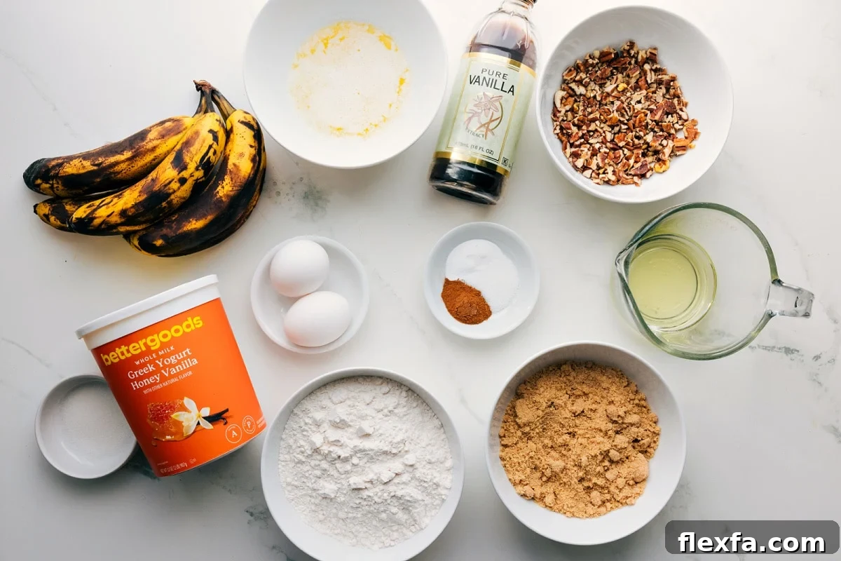 All the ingredients in this recipe prepped out for easy assembly including the bananas, yogurt, flour, sugar, oil, nuts, vanilla, spices, baking agents, eggs, and butter.