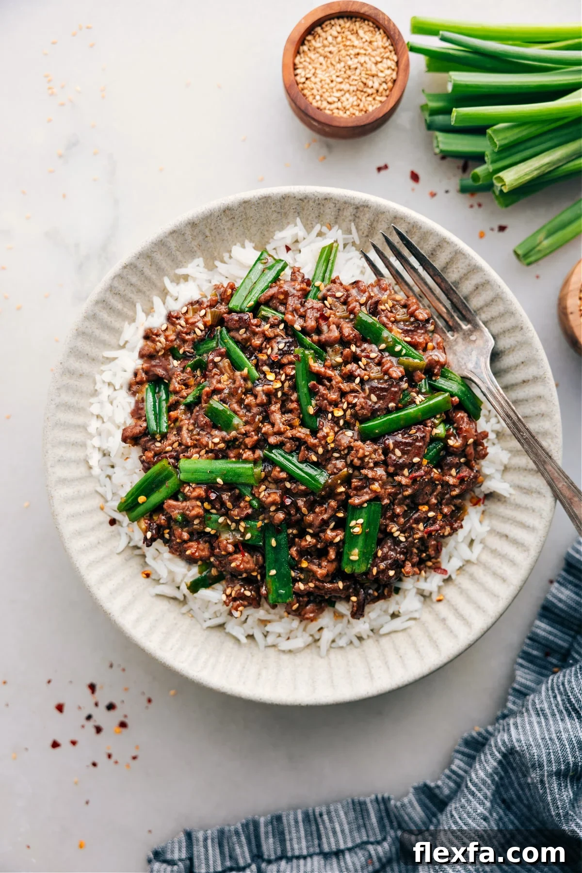 Healthy ground beef recipes Mongolian ground beef in a skillet with green onions and savory stir fry sauce.