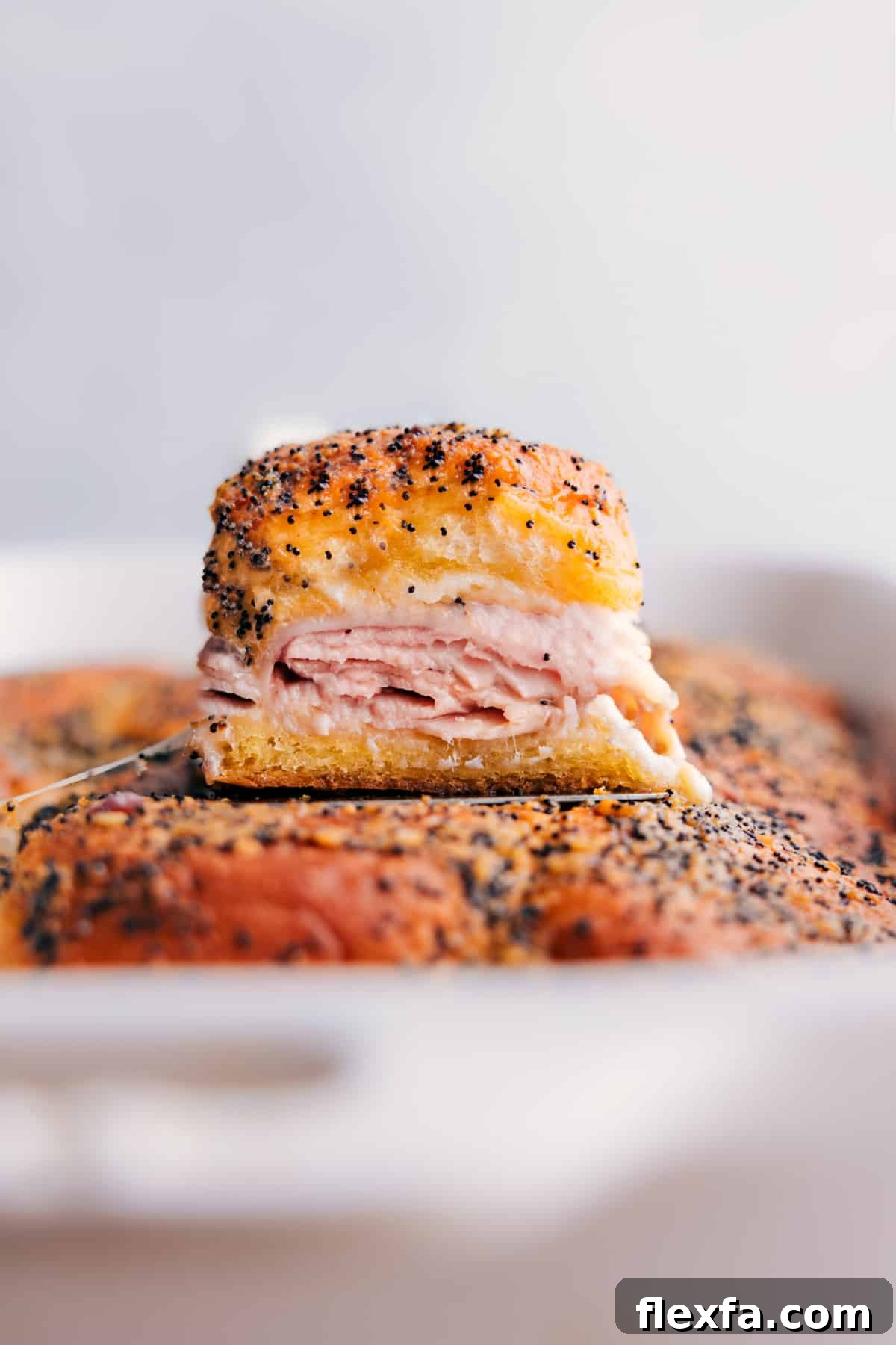 Baked turkey and cheese sliders on soft rolls topped with a buttery herb glaze.