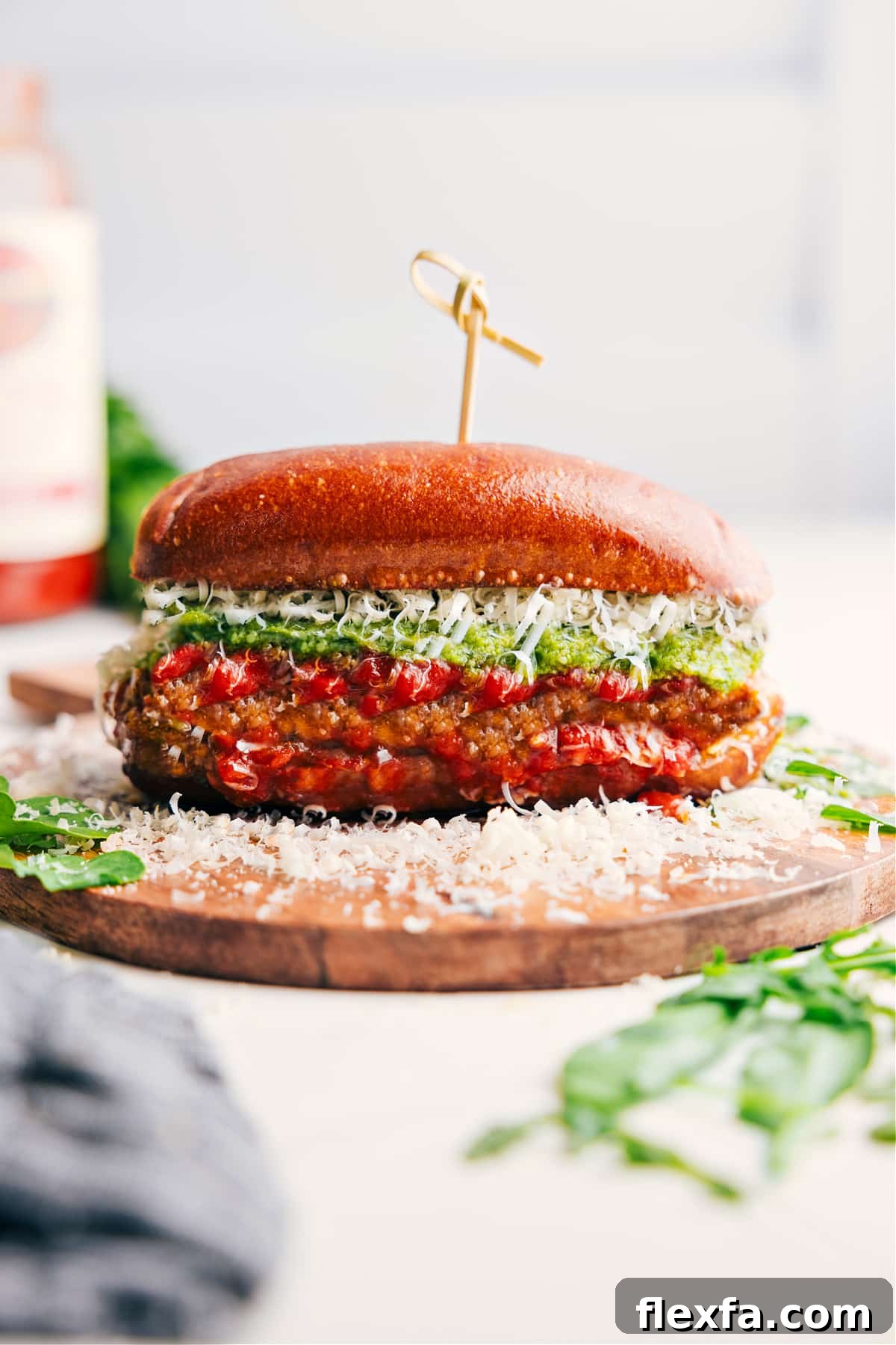 Chicken Parmesan sandwich on a garlic butter roll with pesto and melted cheese.