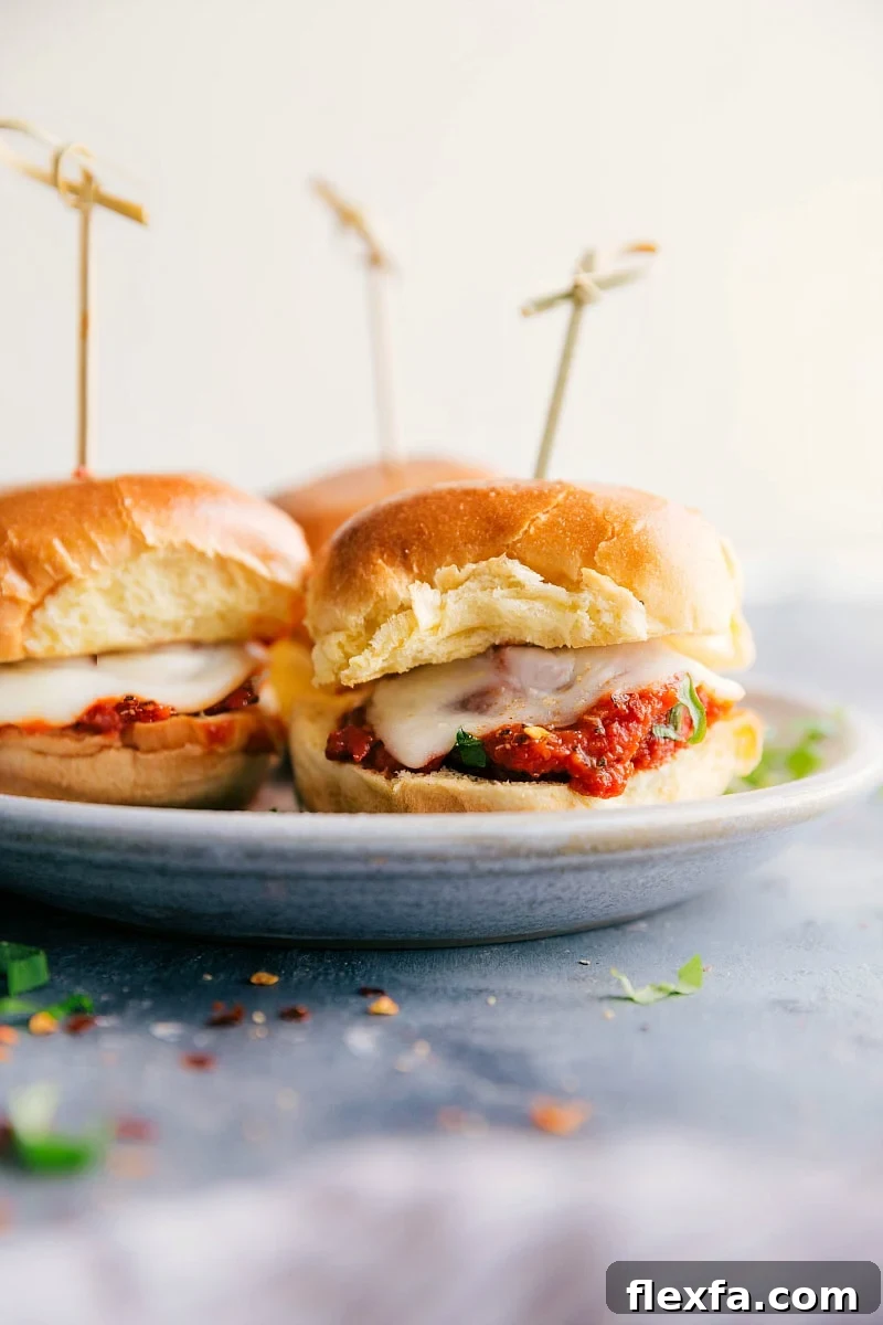 Meatball sliders with saucy meatballs and melted cheese on soft slider rolls.