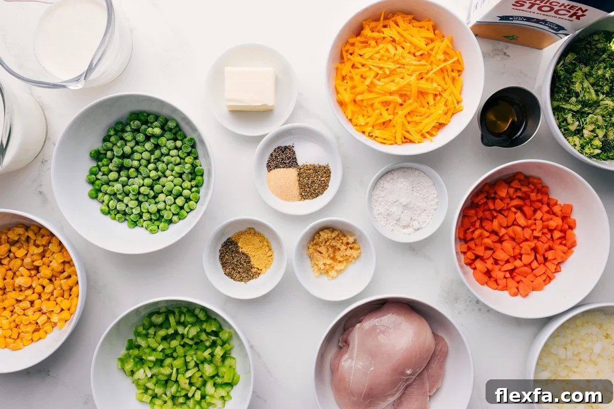 All the ingredients in this recipe prepped out for easy assembly including the milk, peas, corn, celery, seasonings, butter, chicken, cheese, carrots, onions,  broccoli, oil, and stock.