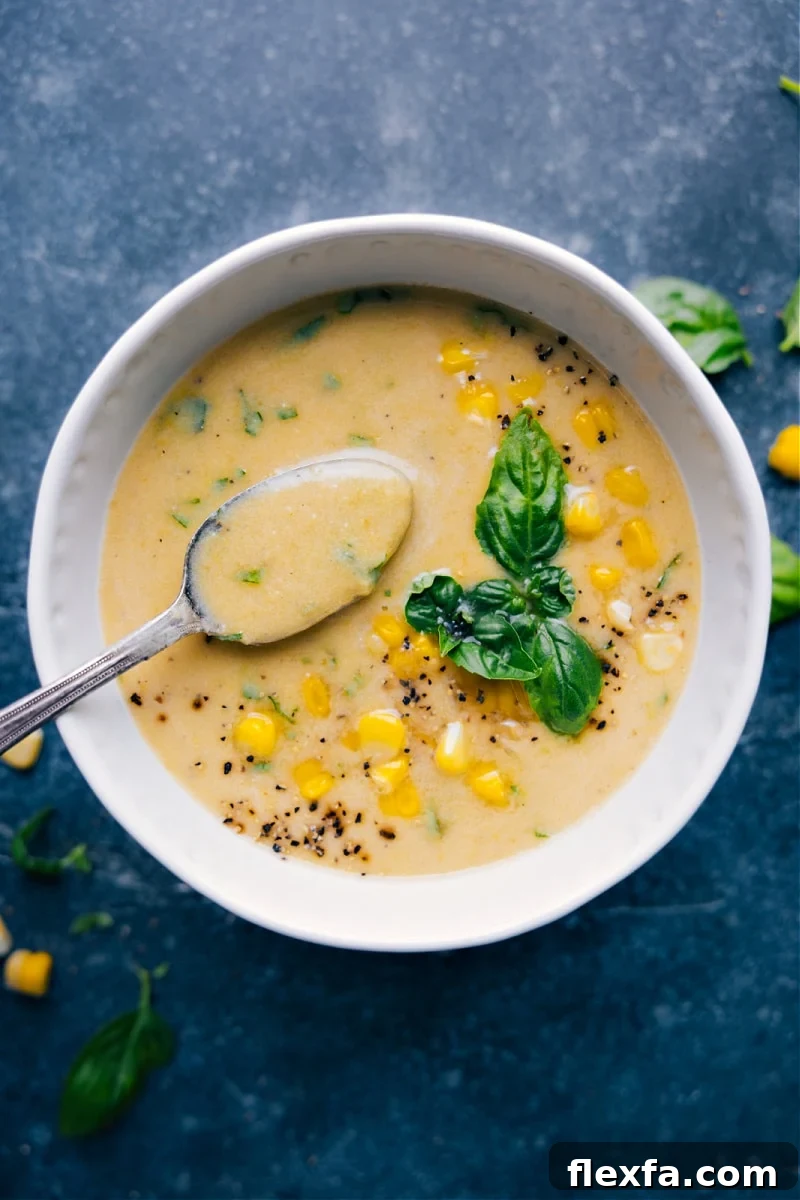 Fresh corn soup with sweet corn and basil in a creamy bowl.