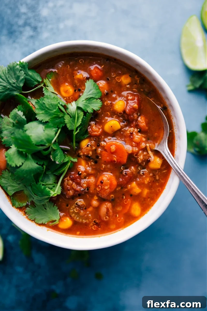 Hearty quinoa soup with shredded chicken, vegetables, quinoa, and warm spices.