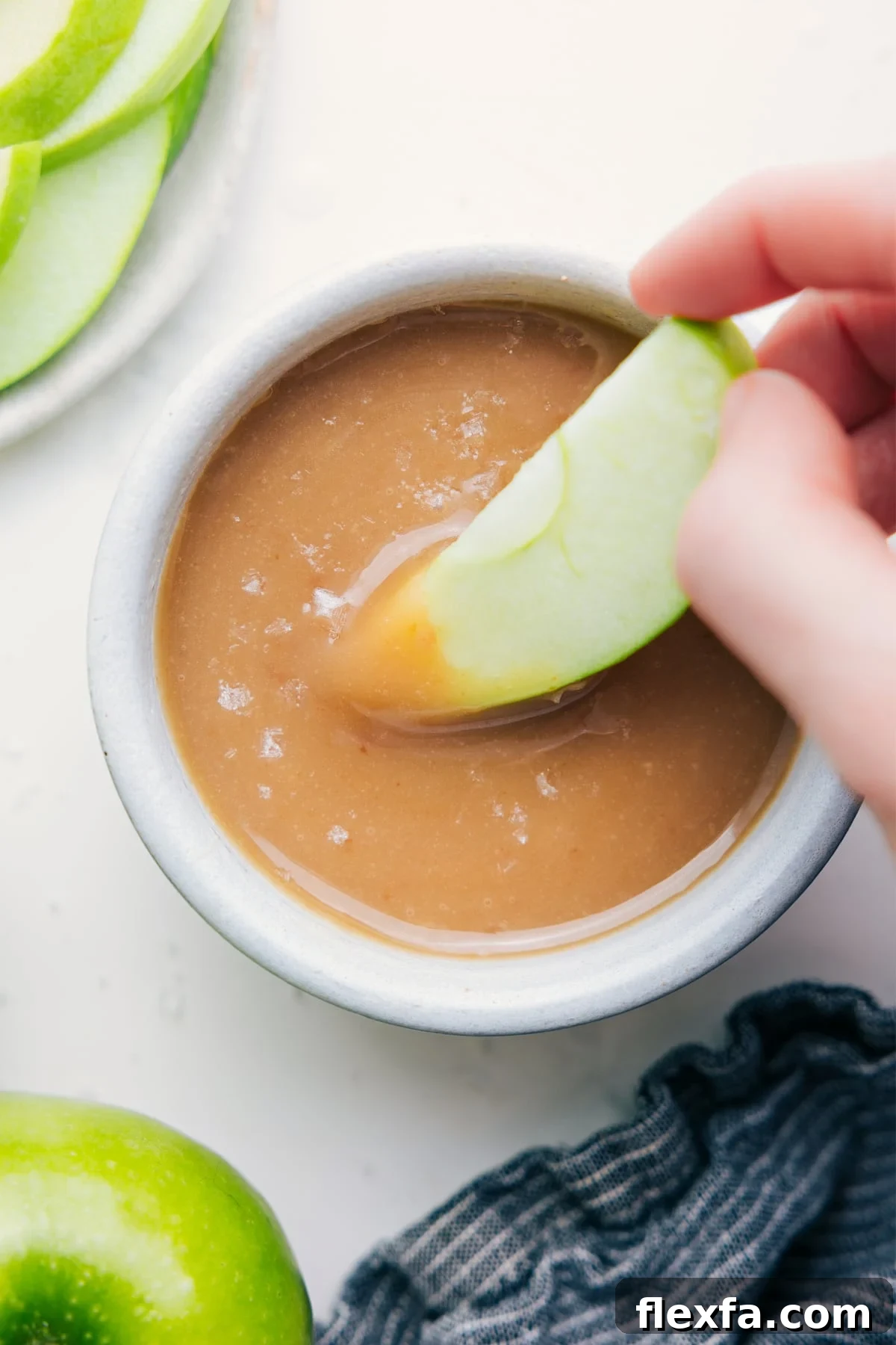 Homemade Caramel Sauce Recipe: Smooth, Pourable Topping 2 Easy Caramel Sauce Recipe with an apple dipped into it.