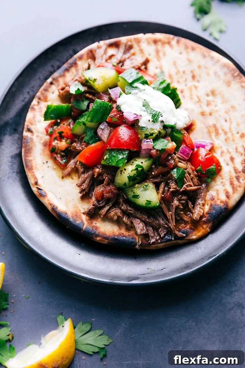 Easy crockpot meals featuring juicy beef gyros on soft pita bread, topped with crisp fresh vegetables and a generous drizzle of tangy sauce, creating a flavorful and satisfying meal.