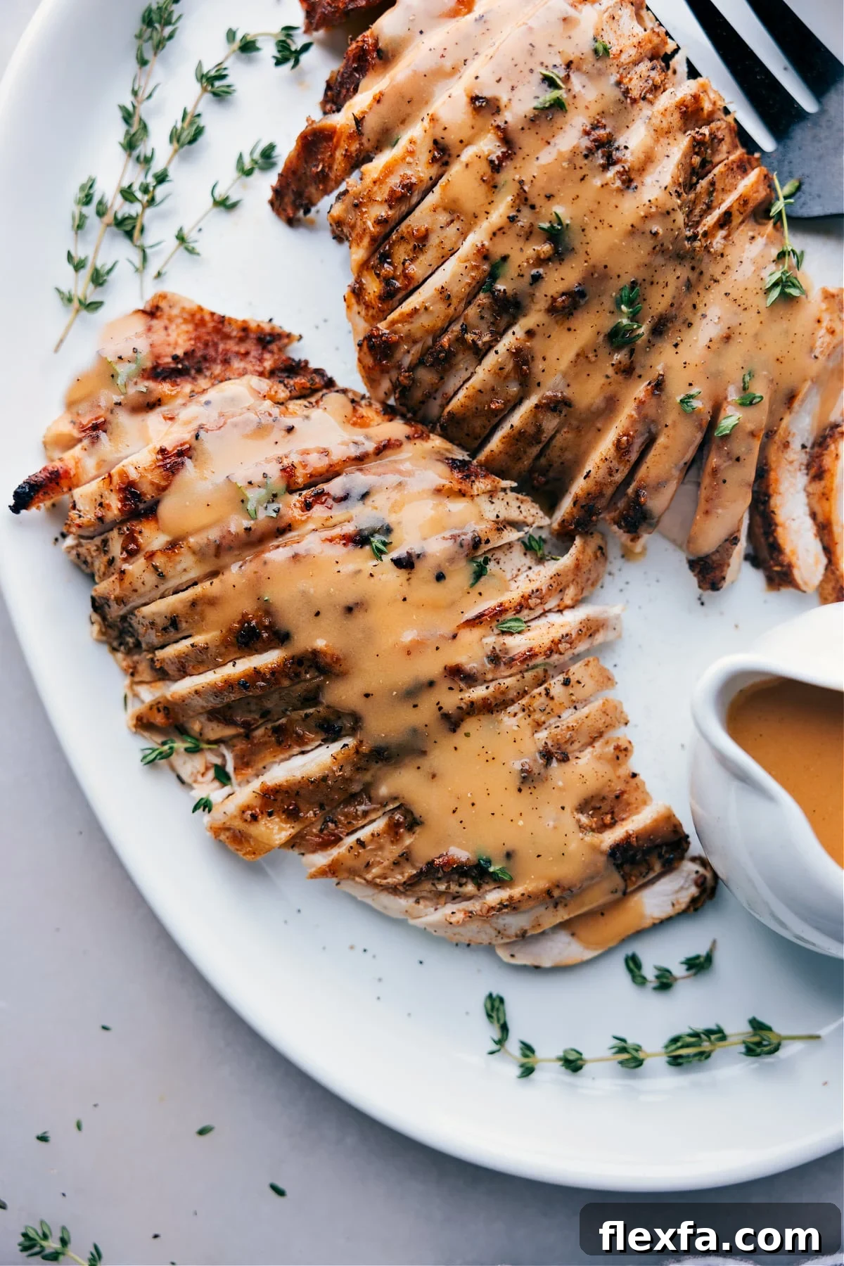 Finished turkey covered in savory gravy, served on a plate, ready for enjoyment.