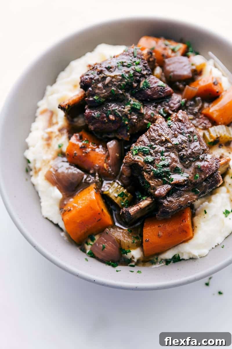 Short ribs recipe fresh out of the slow cooker on a bed of mashed potatoes.