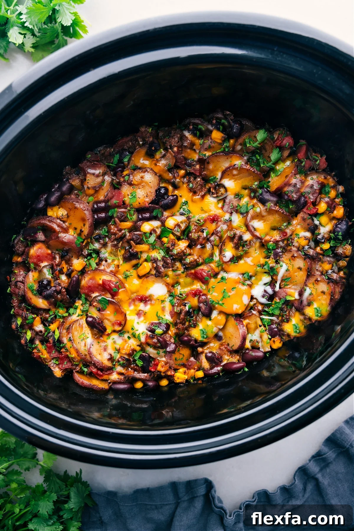 Crockpot cowboy casserole in the slow cooker topped with cheese.
