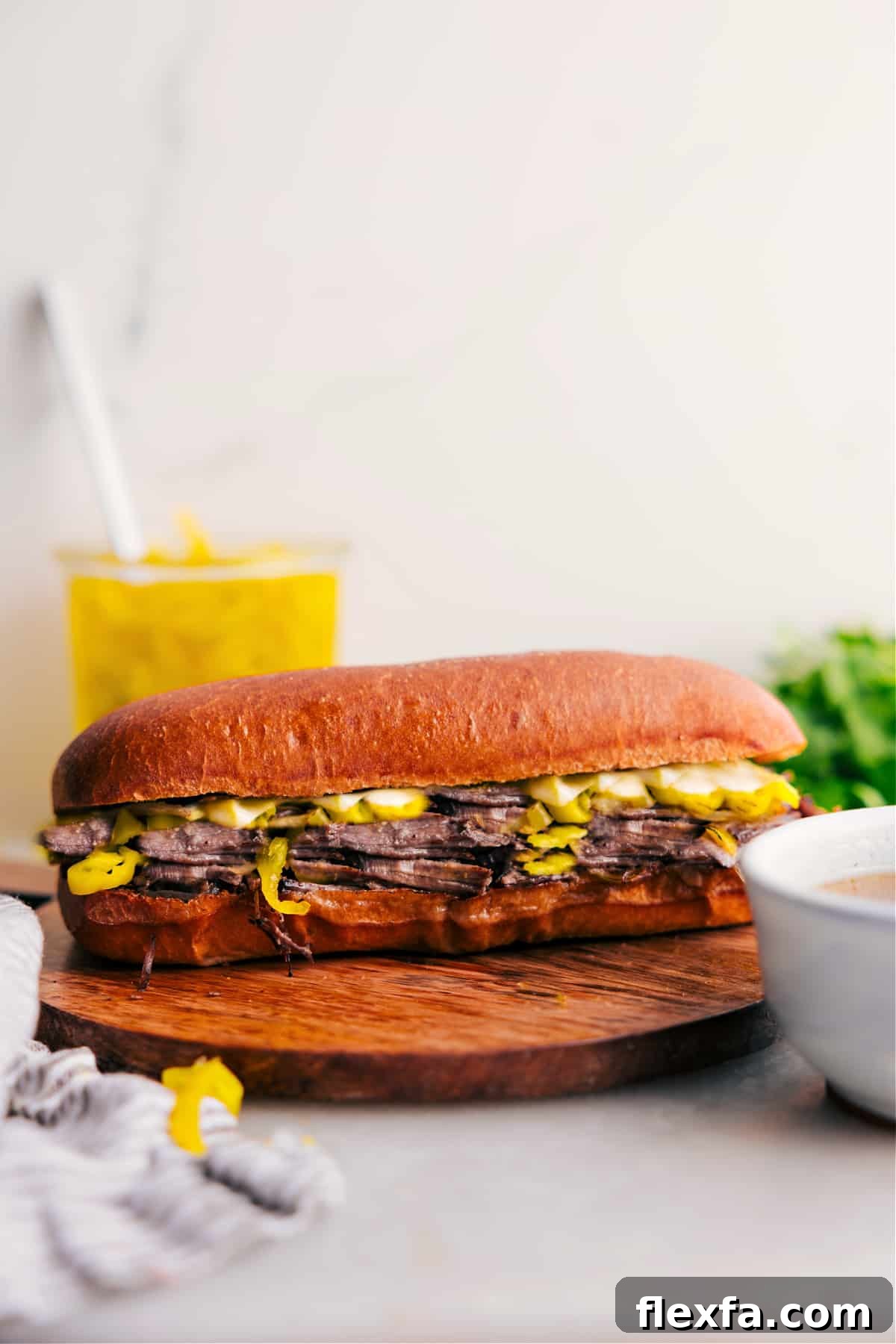 Italian beef sandwich recipe with slow-cooked beef piled into a crusty bun and topped with pepperoncini.