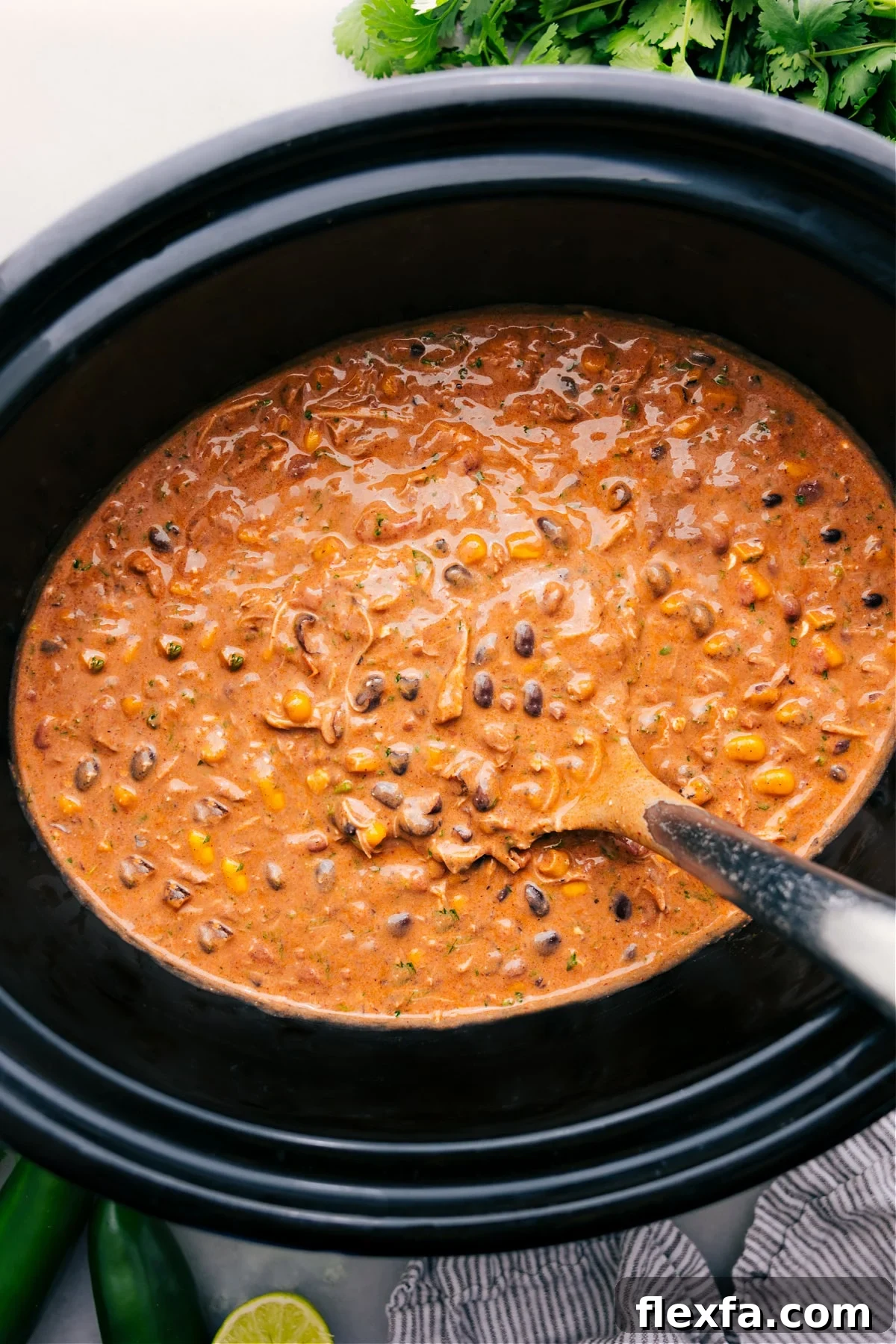 Slow cooker Chicken Chili with tender shredded chicken, sweet corn, beans, and a creamy seasoned broth.