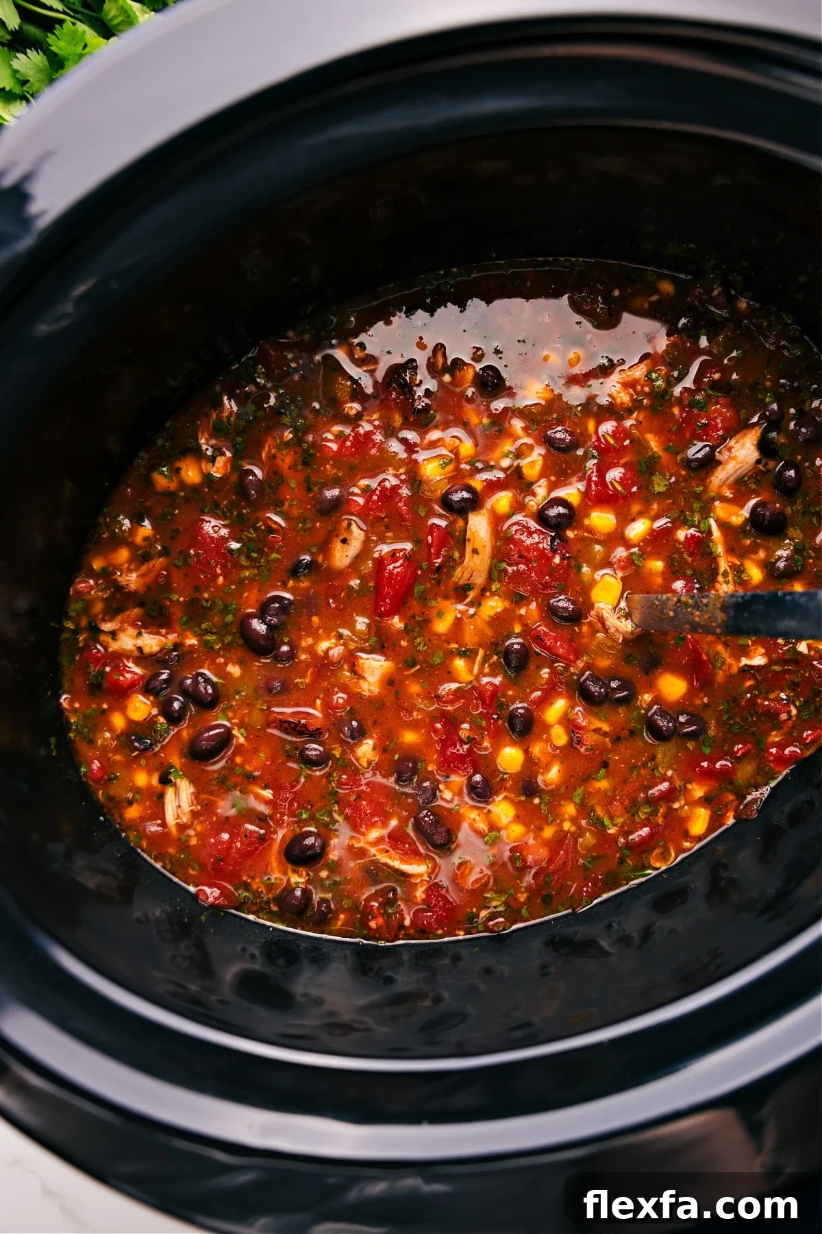 Easy crockpot meals featuring hearty Chicken Taco Soup topped with cheese, avocado, and crunchy tortilla chips.