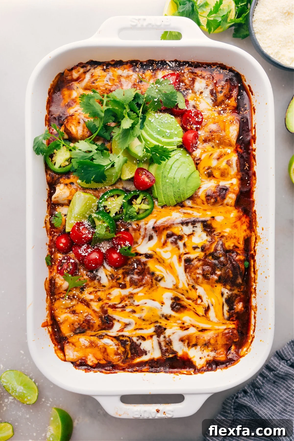 Shredded beef enchiladas topped with avocado, cilantro, tomatoes, and jalapeños.