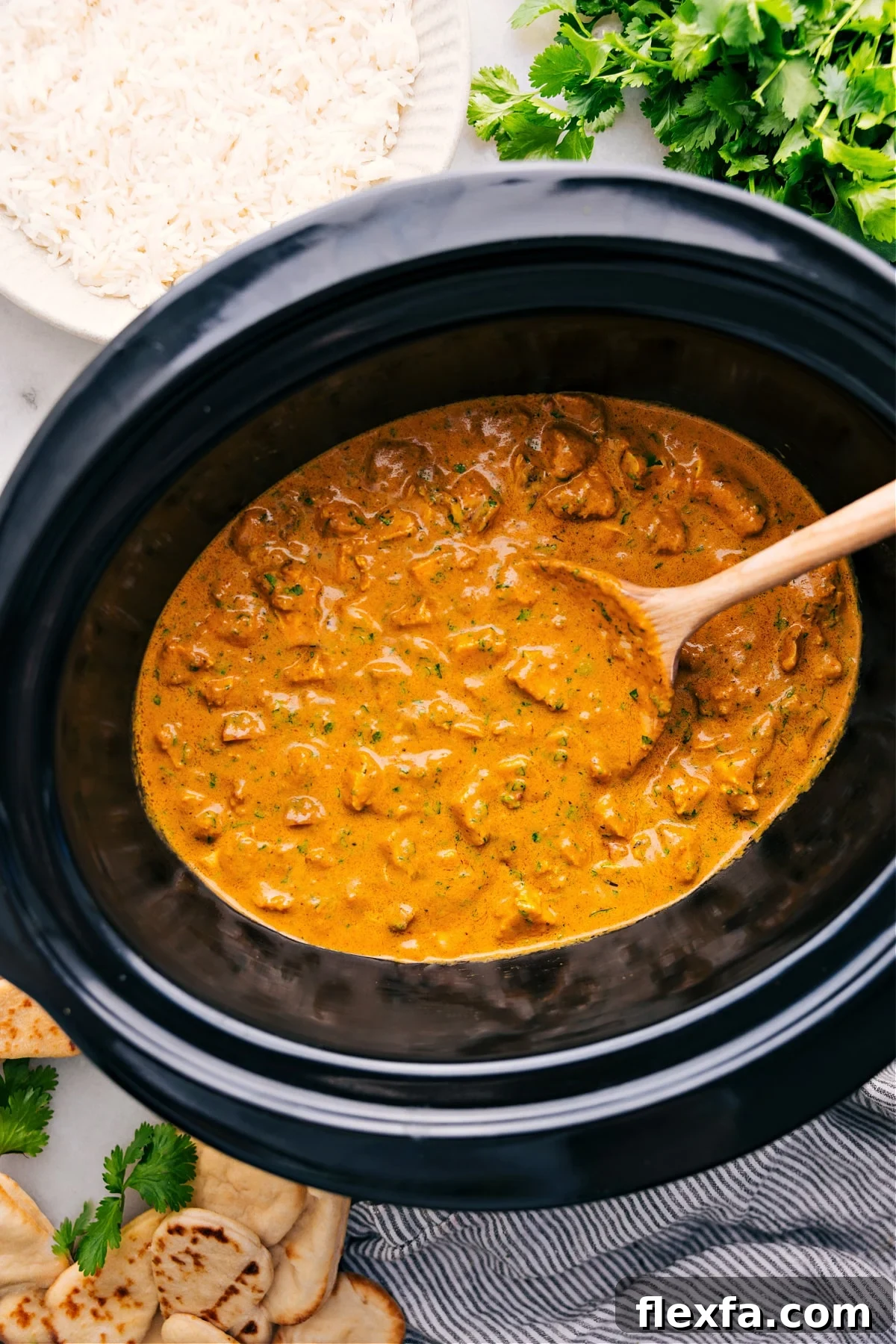 Easy crockpot meals featuring tender butter chicken in a rich, creamy sauce served with rice and naan.